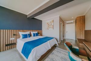 a bedroom with a blue and white bed and a desk at Bellevue Rooms in Stara Baška