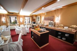 a restaurant with white tables and white chairs in a room at Berghotel Drei Brüder Höhe in Marienberg