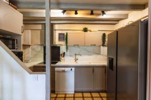 a kitchen with a sink and a refrigerator at La Fernandiere, Historic Home, Garden and Pool in Saint-Georges-sur-Cher