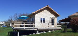mały domek z parasolem na pokładzie w obiekcie Le chalet de Nico w mieście Château-lʼÉvêque