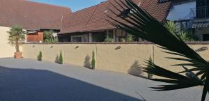 a fence in front of a house with a palm tree at Dreiländereck-Ferienwohnung in Eschbach in Eschbach