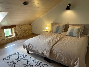 una camera da letto con un letto grande in una mansarda di La Ferme de Belbouys a Soturac