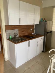 a kitchen with white cabinets and a sink and a refrigerator at Apartamento karma in Culebra