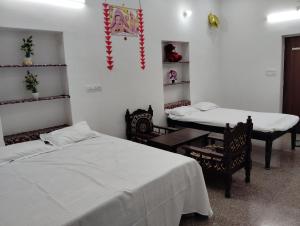 una habitación con dos camas y una mesa y sillas en Krishna Marriott, en Jodhpur