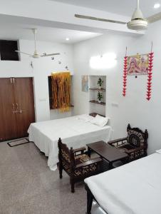 Habitación con 2 camas y 2 sillas. en Krishna Marriott, en Jodhpur