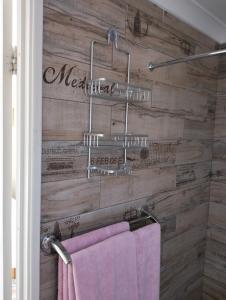 a bathroom with a wooden wall with towels at Avonlea Cottages in York +8 photos