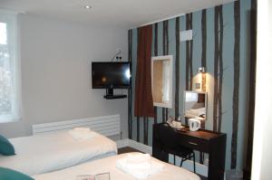 a room with two beds and a desk with a mirror at The Dragonfly in Blackpool