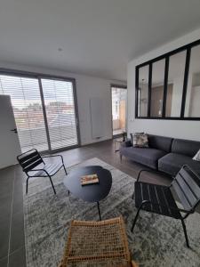 una sala de estar con un sofá, una mesa y sillas en Leon dufour, en Grenoble