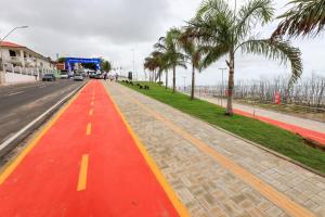 サリノポリスにあるTemporada no Paraiso, Salinópolis te espera- Apartamento no Centro da cidadeのヤシの木が立ち並ぶ赤い道