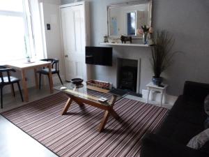 a living room with a coffee table and a fireplace at Wee Ness Cottage in Inverness