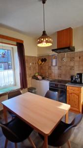 una cocina con mesa de madera y sillas. en Nordseeferienhaus Peter, en Niebüll