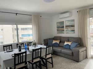 a living room with a table and a couch at SOLMAR Playa Gandia SOLO FAMILIAS in Playa de Gandia