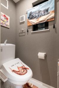 a bathroom with a toilet with aopus on the lid at TOKYO SKYTREE Cat house 押上駅徒歩6分 浅草 in Tokyo