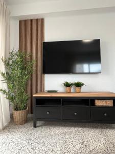 a black entertainment center with a flat screen tv on a wall at SOLMAR Playa Gandia SOLO FAMILIAS in Playa de Gandia