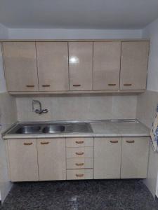 a kitchen with a sink and wooden cabinets at Dehesilla Olive Orchard Retreat in Fuentes de Cesna
