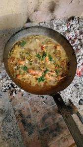a pizza is cooking in a pan on a stove at Dehesilla Olive Orchard Retreat in Fuentes de Cesna