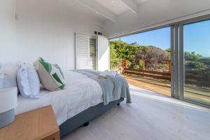 a bedroom with a bed and a large window at Dolphin View Beach Villa in Sedgefield +38 photos