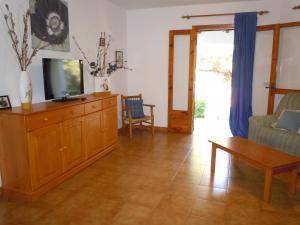 a living room with a tv and a couch at Illa Colom in Cala en Bosc
