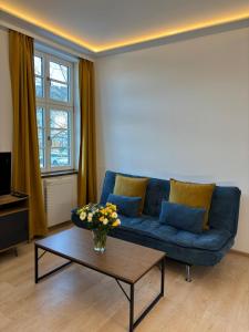 a living room with a blue couch and a coffee table at Alte Postvilla in Oberammergau