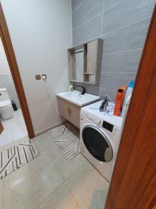 a kitchen with a washing machine and a sink at أفخم شقة فندقيه بالقرب من الحرم المكي in Makkah