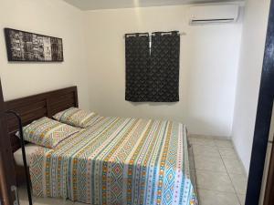 a bedroom with a bed and a towel hanging on the wall at Appartement cosy in Matoury