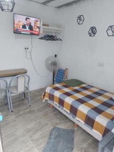 Un dormitorio con una cama, una mesa y un televisor. en Galo 5 San Patricio, en Mar del Plata