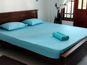 a bed with blue pillows on top of it at WR Family and Holiday Resort in Anuradhapura +28 photos