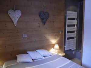 a bedroom with a wooden wall with hearts on it at Appartement Méribel Mottaret 3 chambres, proche pistes, Wifi - FR-1-355-98 in Méribel