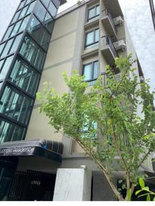 a tall building with a tree in front of it at 51 Suanplu Residence in Bangkok