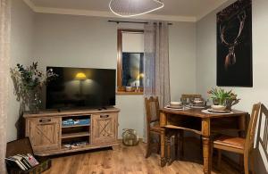 een woonkamer met een tafel en een televisie bij Spreequartier in Malschwitz