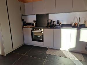 a kitchen with white cabinets and an oven at Chalet 4 chambres, confort moderne, Arêches-Beaufort - FR-1-342-331 in Beaufort +6 photos