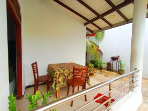 a dining room with a table and chairs on a balcony at White King Guest in Unawatuna