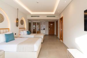 A bed or beds in a room at Sunrise Remal Beach Resort