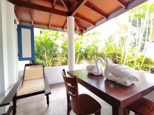 a dining room with a table and chairs on a balcony at White Villa - Homestay in Tangalle