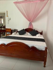 - une chambre avec un lit en bois et une moustiquaire dans l'établissement Southern Breeze Homestay Weligama, à Walliwala East