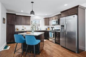 a kitchen with a stainless steel refrigerator and blue chairs at NEW Ivy House 3BR Townhome Downtown Beaches Wineries in Traverse City
