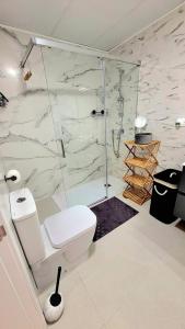 a white bathroom with a shower and a toilet at Casa Rio Madera in San Pedro del Pinatar