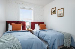 two beds sitting next to each other in a room at NEW Ivy House 3BR Townhome Downtown Beaches Wineries in Traverse City +75 photos