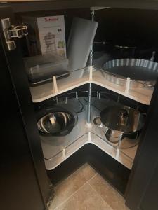 - une armoire avec un bol et des casseroles dans l'établissement Vacances face au Luberon, à Robion 39 autres photos