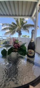 a table with a bottle of beer and a glass at Lakaz Dodo Apartment in Pointe aux Piments