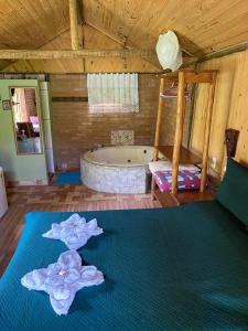 Habitación con bañera y cama con flores en Pousada Chácara Pacheco, en Visconde De Maua