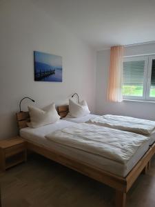 a bedroom with two beds and a window at Ferienwohnungen Meyer in Heilsbronn