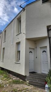 un edificio blanco con dos puertas blancas. en Appartement F2 Orléans 42m2, parking, 4 couchages et lit bébé, en Orléans