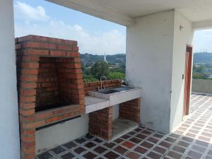a kitchen with a sink and a brick oven at Económico práctico central in Cúcuta