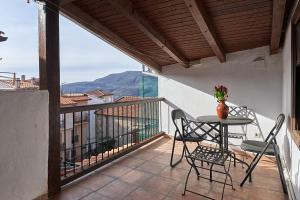 a patio with a table and chairs on a balcony at El Capricho del Jerte in Casas del Castañar