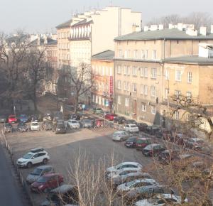 un parcheggio con auto parcheggiate di fronte agli edifici di Carmen Apartment a Cracovia