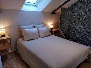 a bedroom with a bed with two lamps on two tables at VKLS 4 Appartement T2 in Languidic