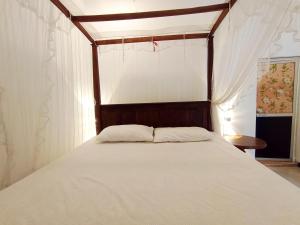 a bedroom with a bed with a wooden head board at White King Guest in Unawatuna