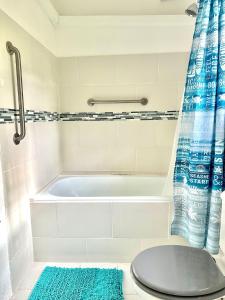 a white bathroom with a tub and a toilet at South Coast - Private in Christ Church +31 photos