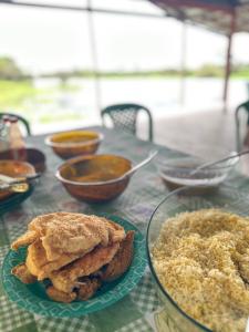 a table with a plate of food and rice at Pousada Araçá Adventure in Sao Pedro